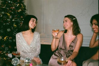 Three Women Laughing Beside Christmas Tree